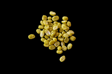 Split mung bean isolated on black color background, Yellow bean peeled split on top view.の写真素材