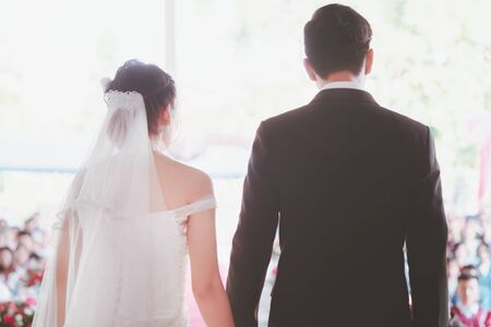 The bride and groom hold hands with soft focus. Picture of happiness in the wedding day ceremony.の写真素材