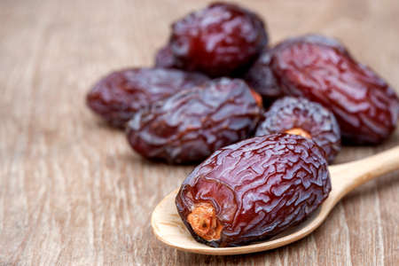 Close-up Medjool dates or dates fruit in wooden spoon on table, This fruit is highly nutritious and...