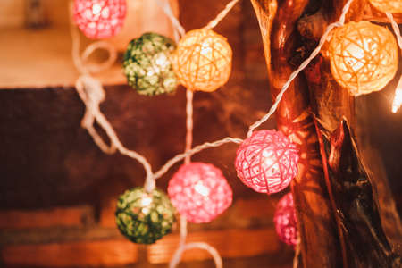 Colorful cotton ball light bulbs hanging on the wall with bokeh background.