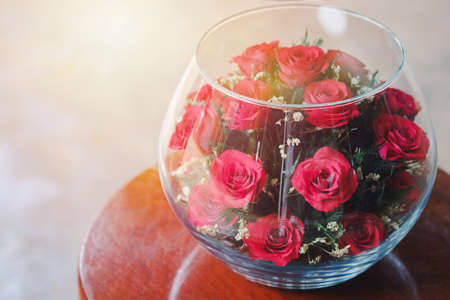 Red roses adorned in large glass jars on the table to decorate the interior of the house. Gift ideas for lovers.の写真素材