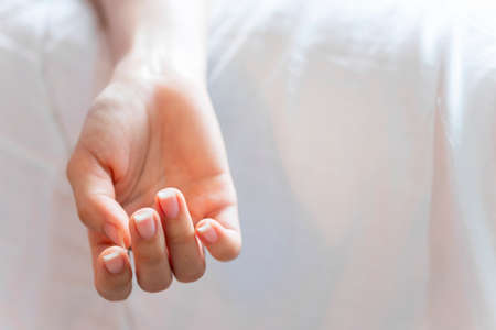 The woman committing suicide by overdosing on medication. Closeup of lurid hand of dead body. The concept of die alone, Copy space background.の写真素材