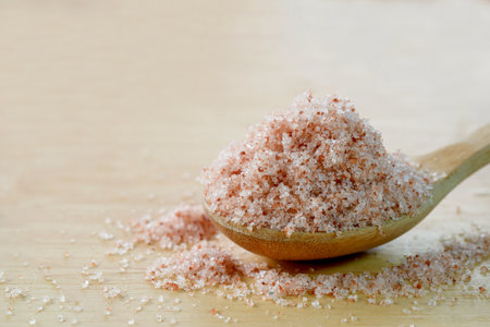 Close-up of Pink Himalayan salt in a wooden spoon on the table. Healthy food concept.の写真素材