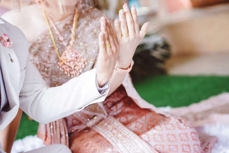 A married couple shows a wedding ring on their finger. Wedding in thailand.の写真素材