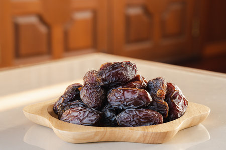 Medjool dates in a wooden container on the table. It is the king of dates with the largest size.