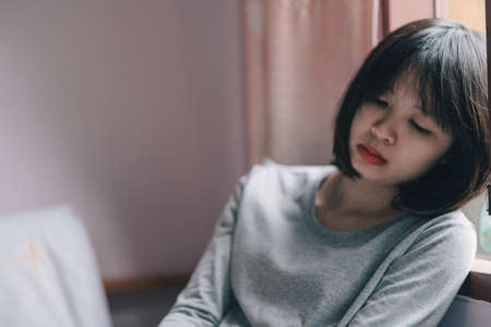 A woman sits sad in the bedroom. depression.の写真素材