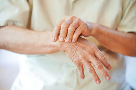 Wrist pain in the elderly or diseases related to rheumatism. Concept of health problems in the elderly.の写真素材