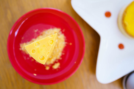 Cheese cake or cake shaped like cheese on a red plate in a cafe.