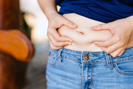 Women who have a lot of belly fat because of eating unhealthy food. Health care concept.の写真素材