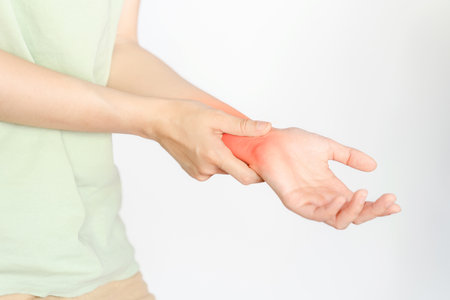 A woman holding her wrist due to an injury or rheumatoid arthritis.
