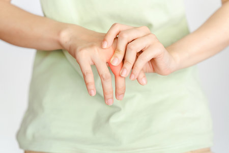 A woman touches her knuckle because of an injury or rheumatoid arthritis.