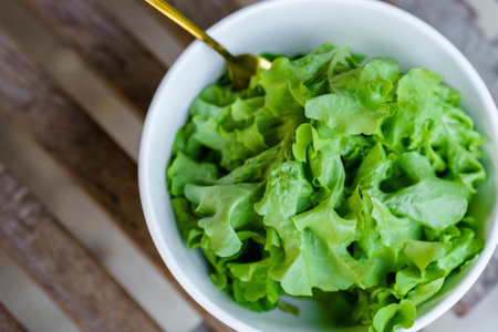 Assorted salad vegetables in white bowls on wooden table. Healthy food concept.の写真素材