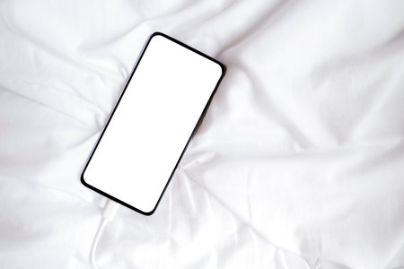 White blank screen smartphone for inserting pictures or advertising text on white fabric. Clipping path. Copy space.の写真素材