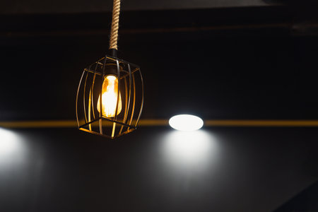 Decorative lamp with iron frame suspended from the ceiling, illuminating in gold. Interior concept.の写真素材