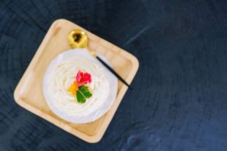 Fresh cream cake or fresh milk cake on plate with spoon on black wooden background.の写真素材