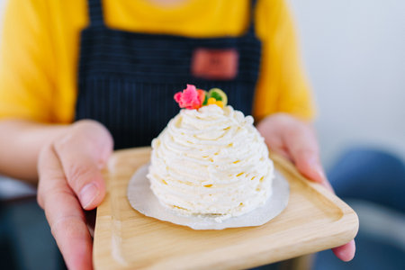 Delicious handmade cakes on plates held by waiters.