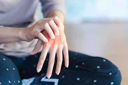 A woman has pain in her palm because of a pinched nerve in her hand. It is caused by using your hands and wrists to do a lot of work for a long time.の写真素材
