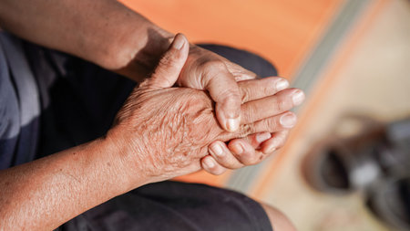 image captures hands of elderly person, showcasing intricate details of age and experience. hands are clasped together, reflecting moment of contemplation or rest.の写真素材