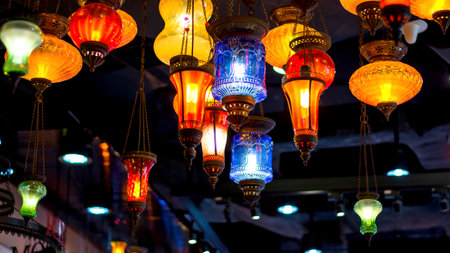 A vibrant display of colorful hanging lanterns, showcasing intricate designs and illuminating the space with a warm glow.の写真素材