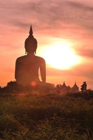 Angthong, Thailand - June 19, 2010: Unidentified woman rides her bicycle to Wat Muang temple in the morning.のeditorial素材