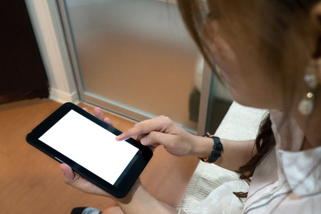 Hands of Asian woman using her tablet with blank white screen.の写真素材