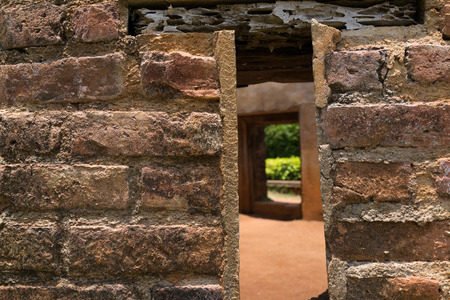 Close up of small window on the weathered brick wall.の写真素材