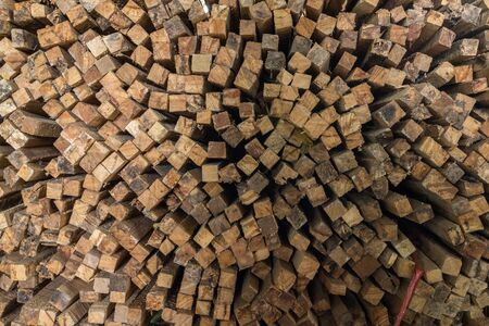 Texture and random pattern of pile of brown rough sawn timber.