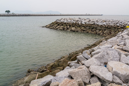 Long stone seawall in the sea.の写真素材