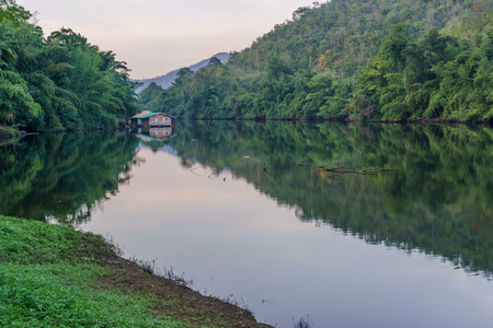 Small bamboo raft houses floating on lake with reflection in the forest.の写真素材