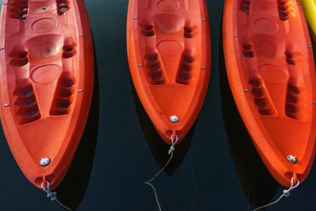 Red kayaks floating on dark blue water.の写真素材