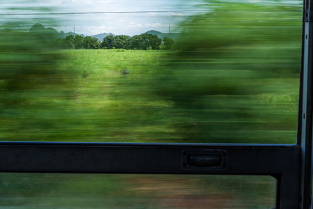 Motion blur of train window view with green trees and blue sky.の写真素材