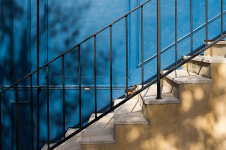 Trees shadow on old yellow stairs and blue wooden wall.の写真素材