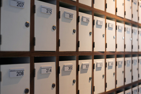 Small closed mail lockers in wooden boxes with room numbers