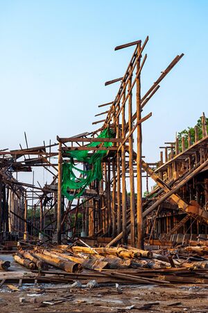 Wood frame construction and log piles of an old demolished rice mill in Thailand.の写真素材
