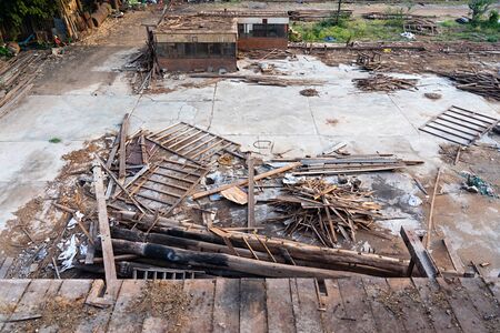 Piles of wood and garbage at demolished old rice mill in Thailand.