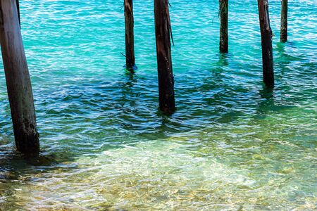 Abstract of old wooden poles in clear turquoise sea.の写真素材