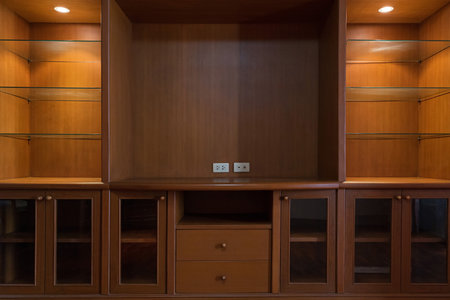 Empty wooden TV storage combination with shelves, cupboards, drawers and lights.の写真素材