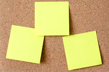 Office paper sheet or sticky note on cork board background,Front view. Close up.
