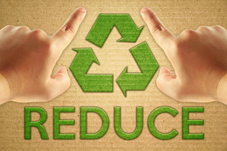 Recycle green symbol on cardboard with text reduce and man hand focus point.の写真素材
