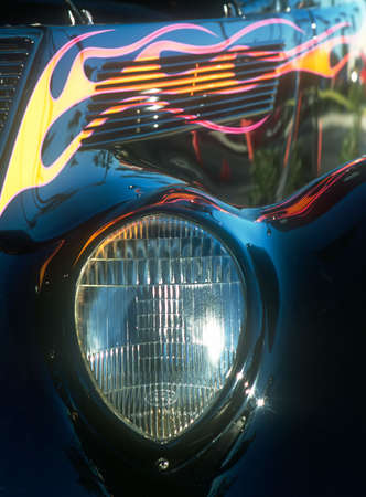 Car - roadster - tight view of front headlight and side of engine compartment - flame paint highlightsの写真素材