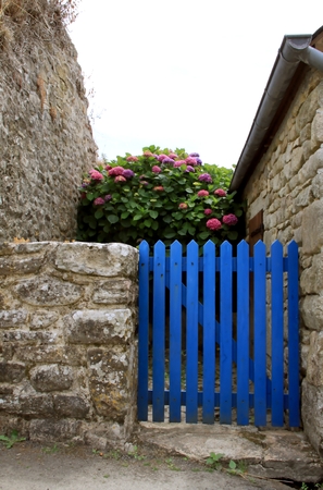 Blue garden gate with stone wall in Brittanyの写真素材