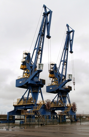 Large harbor cranes in blue and yellow