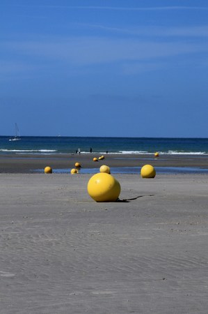 Yellow buoys at low tide in northern Franceの写真素材