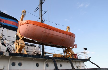Orange rescue boat on a shipの写真素材