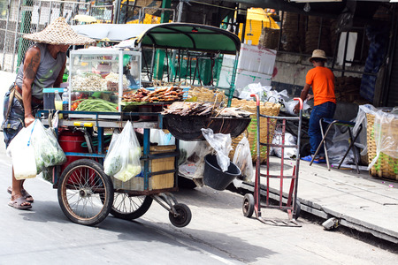 Man pushing Street food vendor cart in Thailandの写真素材