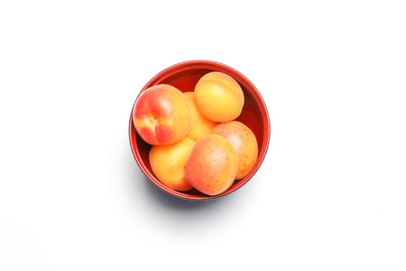 Apricot fruit sweet red yellow whole dry in bowl on white backgroundの写真素材