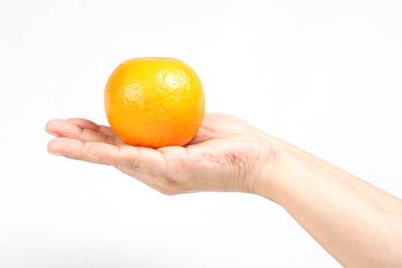 Orange held on hand finger on white backgroundの写真素材
