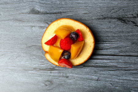 Fruit cream roll cake slice pastry mango strawberry blackberryの写真素材