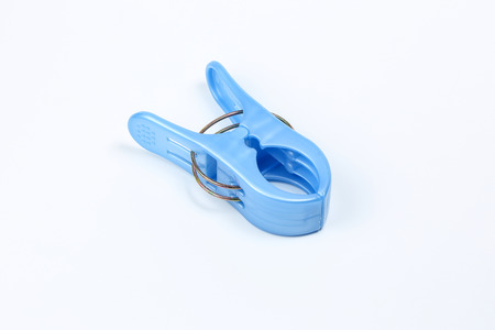 Blue plastic cloth pin clip on white backgroundの写真素材