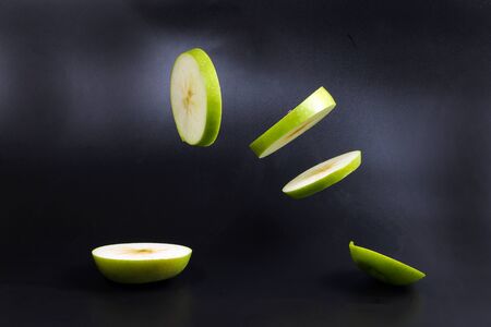 Levitated green apple slices flying air gravity deifying の写真素材
